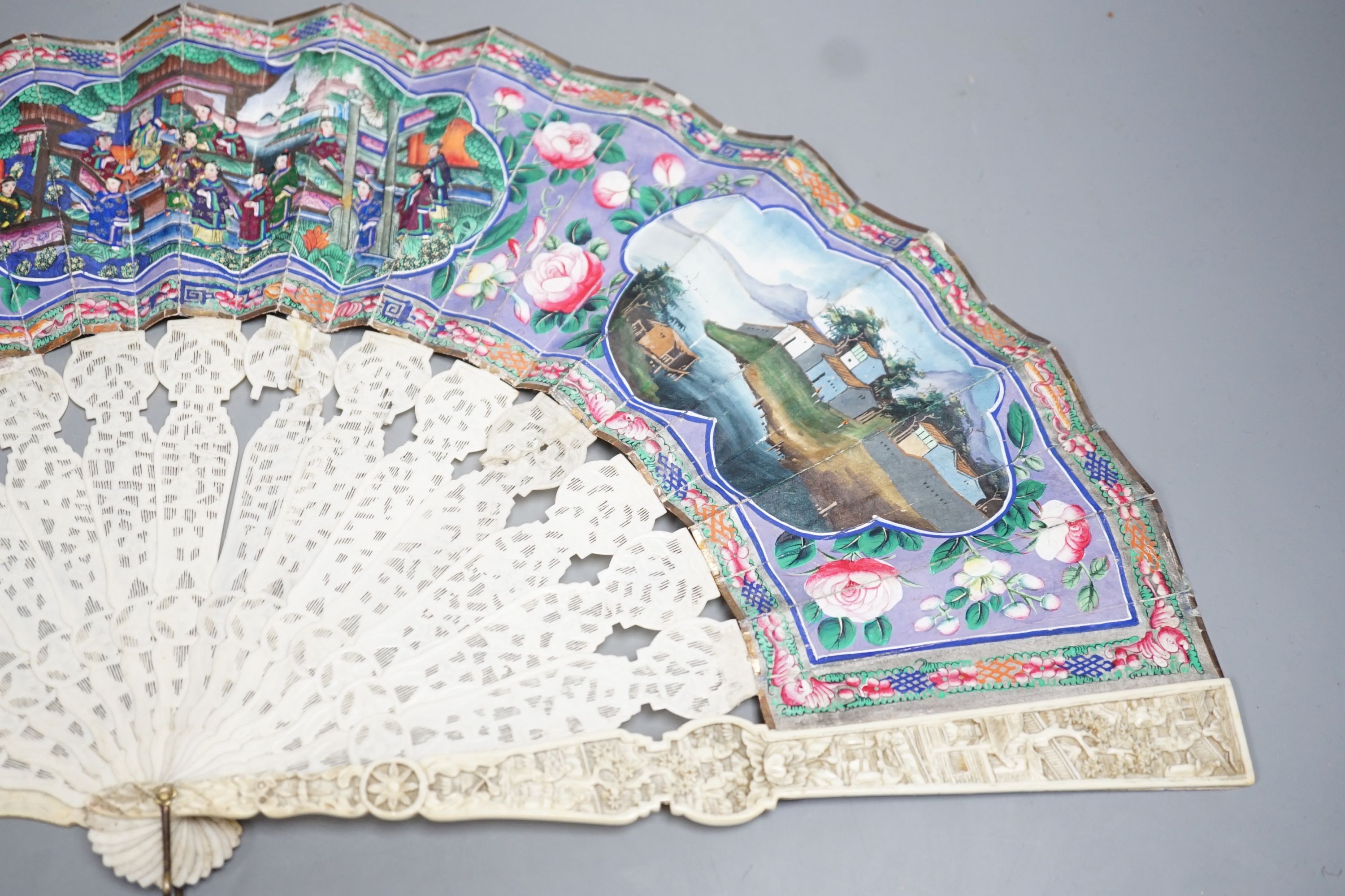 A 19th century Chinese export pierced ivory and painted paper leaf fan, in box. Fan 28cm long